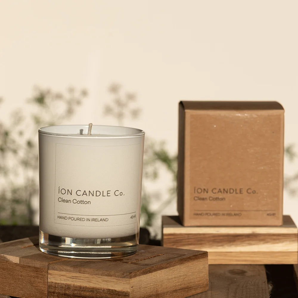 Ion Candle Co. - Clean Cotton Luxury Scented Candle, placed on a wooden black against a floral background