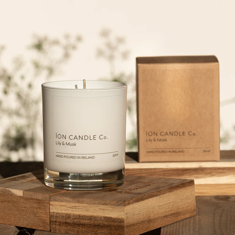 Ion Candle Co. - Lily and Musk Luxury Scented Candle on a wooden block against floral background