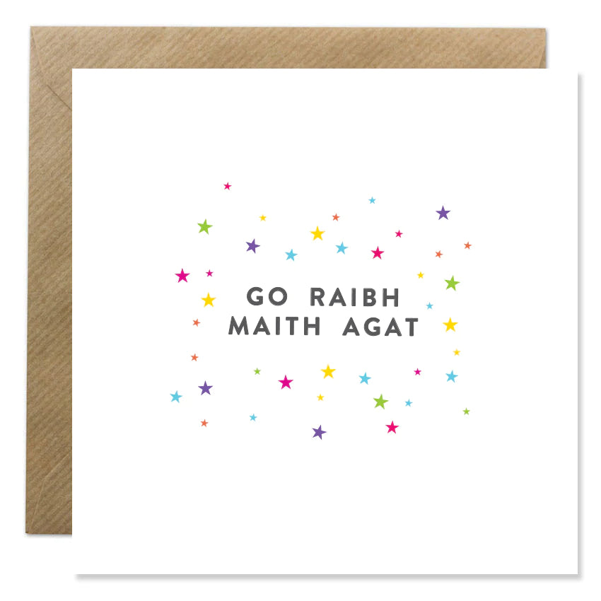 Ion Candle Co. - 'Go Raibh Maith Agat' greeting card. The card is white with multiple coloured stars of varying sizes scattered around the text in the centre which is a soft black.