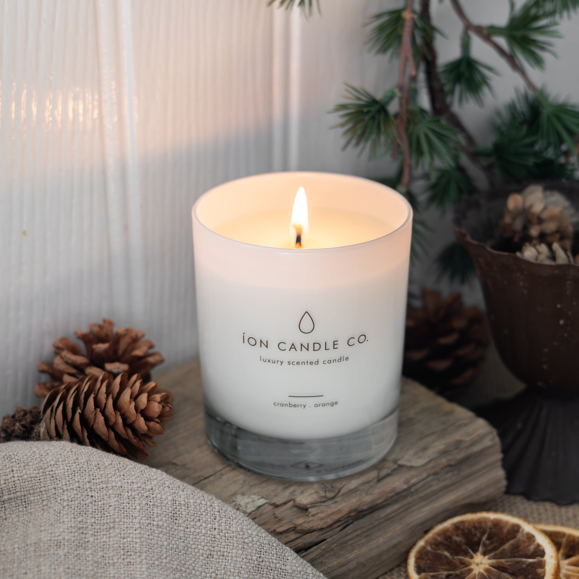 Candle from Ion Candle Co. on a wooden surface with decorative elements