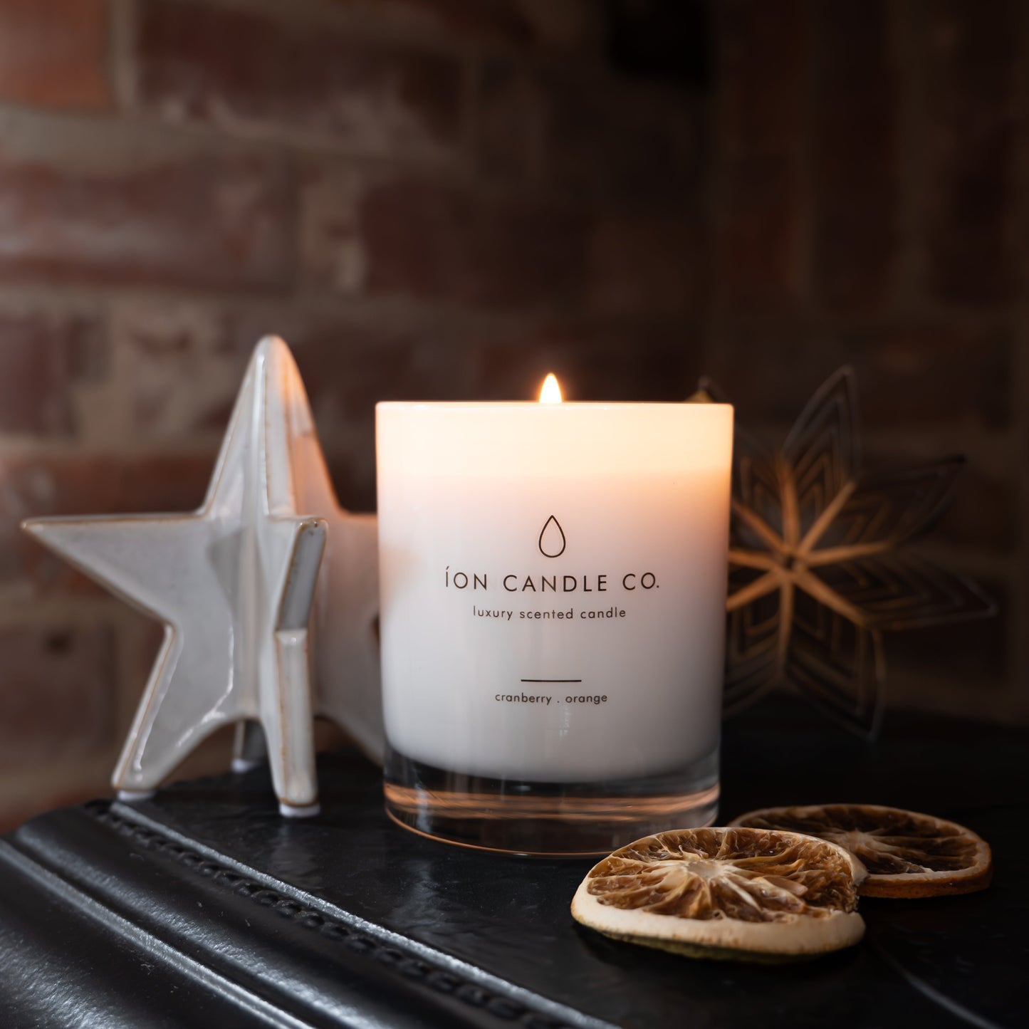Candle with 'ION Candle Co' branding on a dark surface with decorative elements.