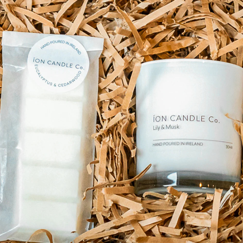 Ion Candles - close up photo of a Candle and Wax Melt gift set in beautiful cardboard packaging with straw-like material as filler to cushion the products. 