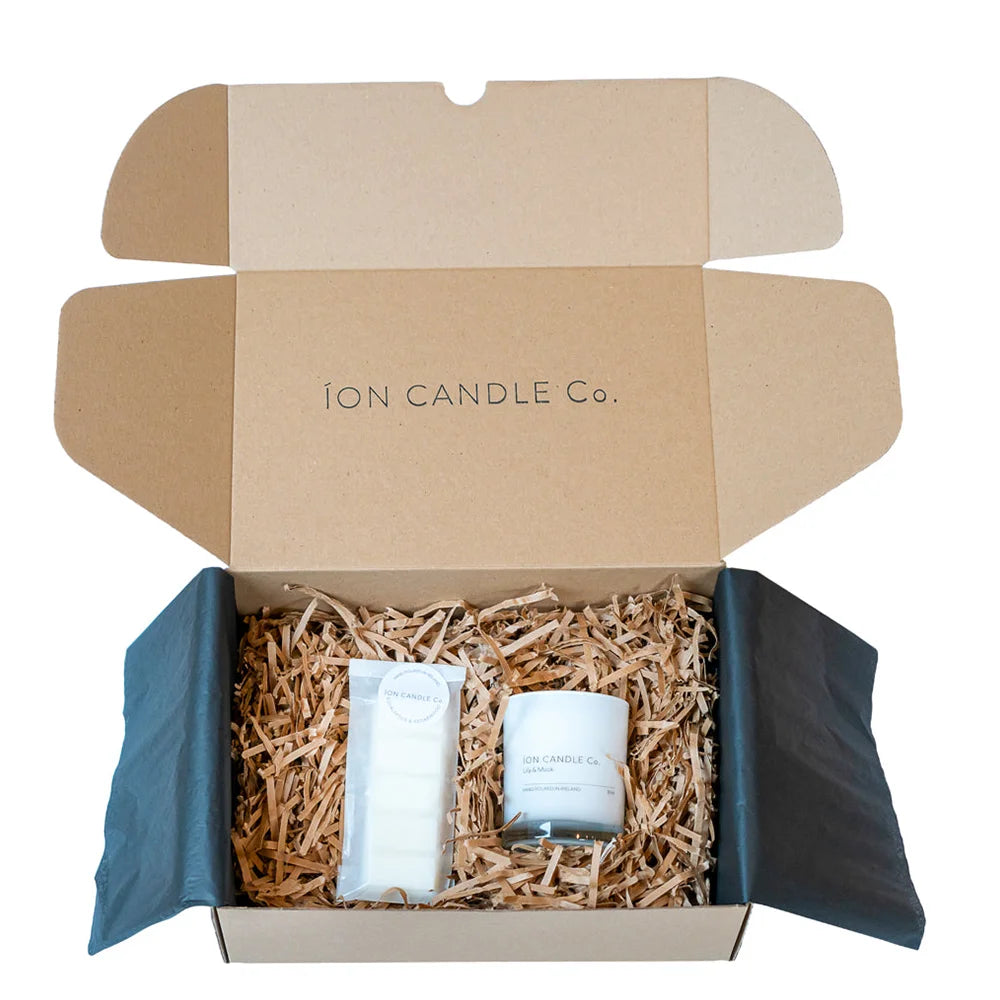Ion Candles - Candle and Wax Melt gift set in beautiful cardboard packaging with straw-like material as filler to cushion the products. Taken against a white background.