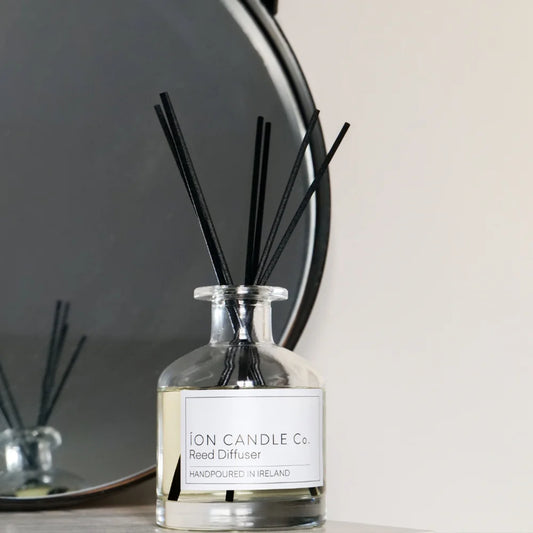 Ion Candle Co. - Reed Diffuser bottle sat against a white background with a circular mirror to the left 