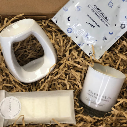 Ion Candle Co. - Pamper me bundle which includes scented sleep masks, wax burners, wax melts and scented candle, all placed carefully in their packaging which is filled with a straw-like material to cushion the products