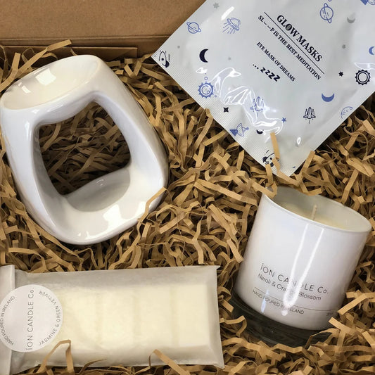 Ion Candle Co. - Pamper me bundle which includes scented sleep masks, wax burners, wax melts and scented candle, all placed carefully in their packaging which is filled with a straw-like material to cushion the products