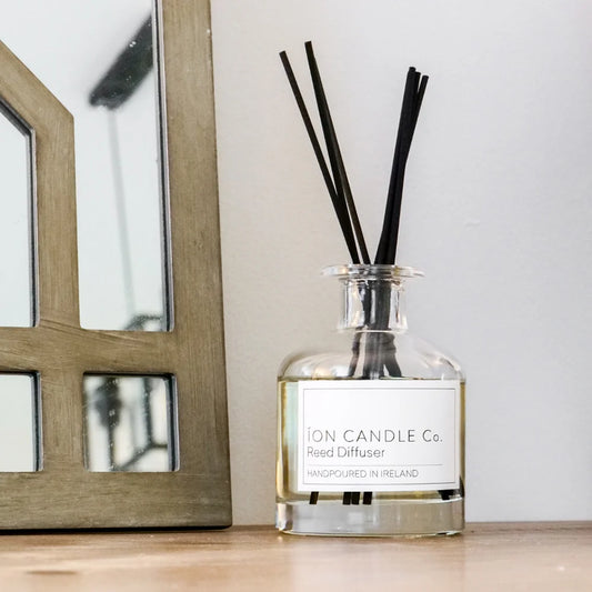 Ion Candle Co. - Scented Reed Diffuser bottle on a small wooden stand against a white background