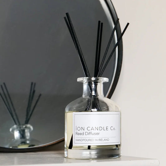 Ion Candle Co. - Eucalyptus and Cedarwood Reed Diffuser bottle against a white background with a mirror to the left