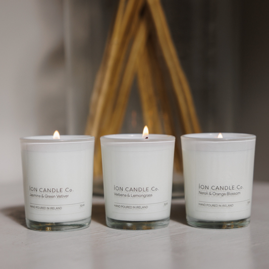 Ion Candle Co. - Gift Set of 3 candles set on a white base with a backdrop of a vase with reeds. Jasmine & Green vetiver, verbena & lemongrass, neroli & orange blossom 