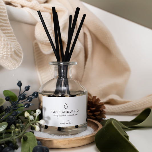 Diffuser with reeds and a label on a surface with decorative elements