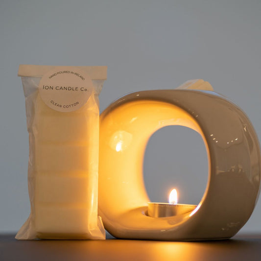 Ion Candle Co. - Luxury scented clean cotton wax melt with wax burner against a grey background. 