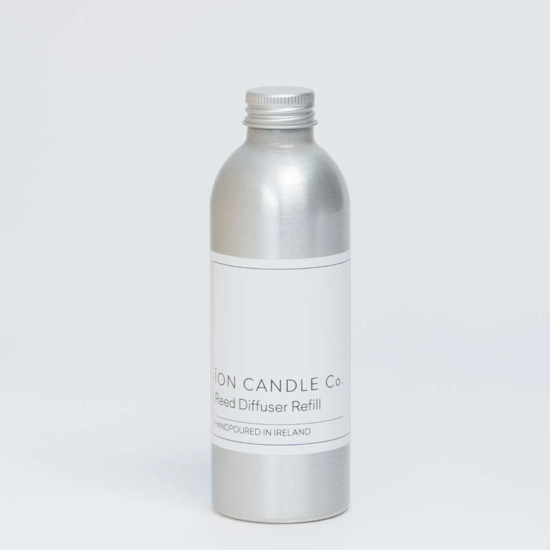 Ion Candle Co. - Eucalyptus and Cedarwood Reed Diffuser Refill bottle which is shiny metallic grey with a white label and black text. Taken against a tan brown background